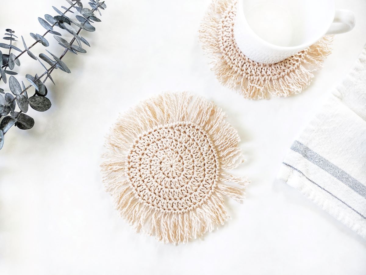 a boho crochet coaster with fringe made out of cotton yarn 