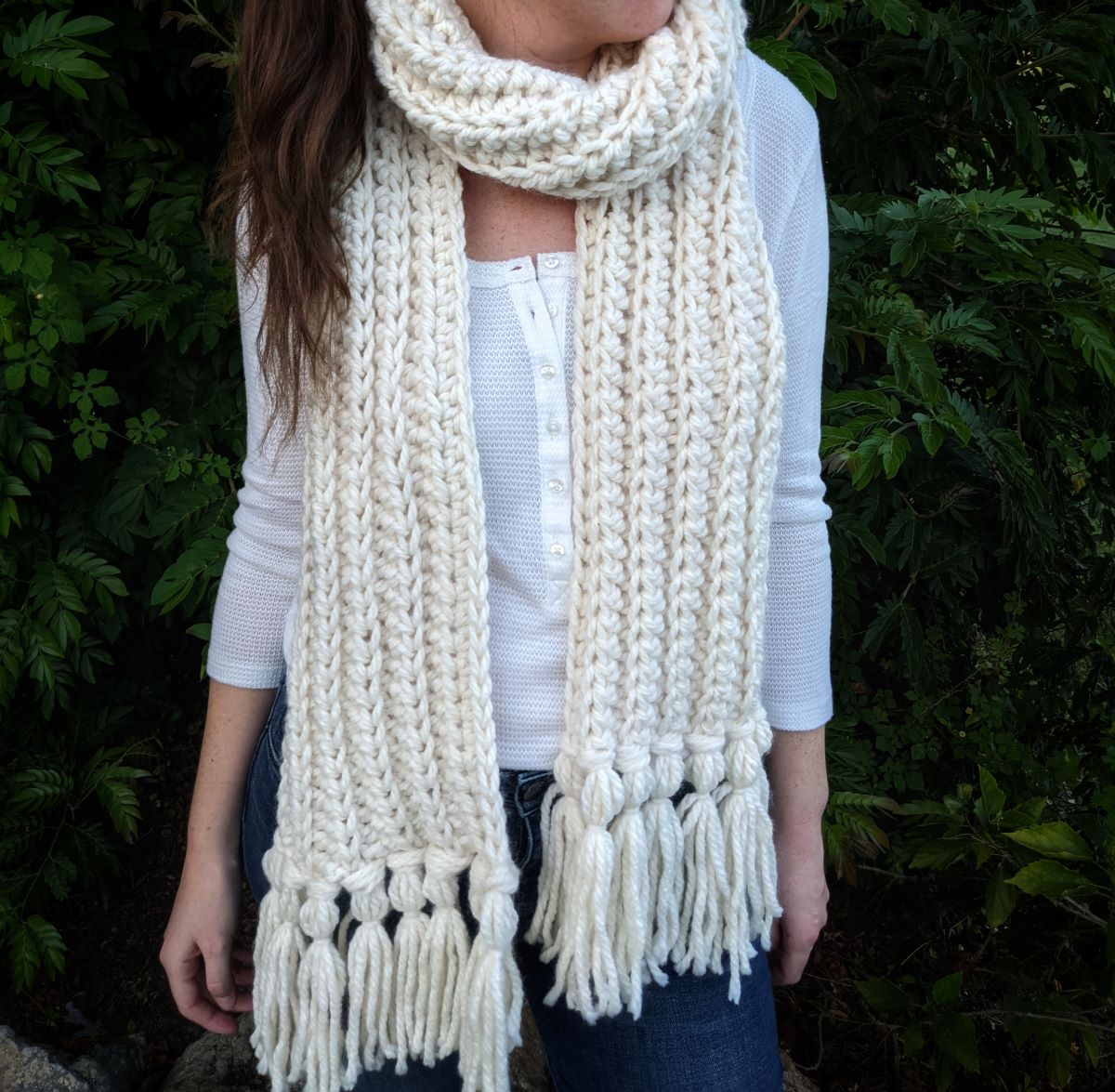 model is wearing a bulky weight crochet scarf in the color fisherman