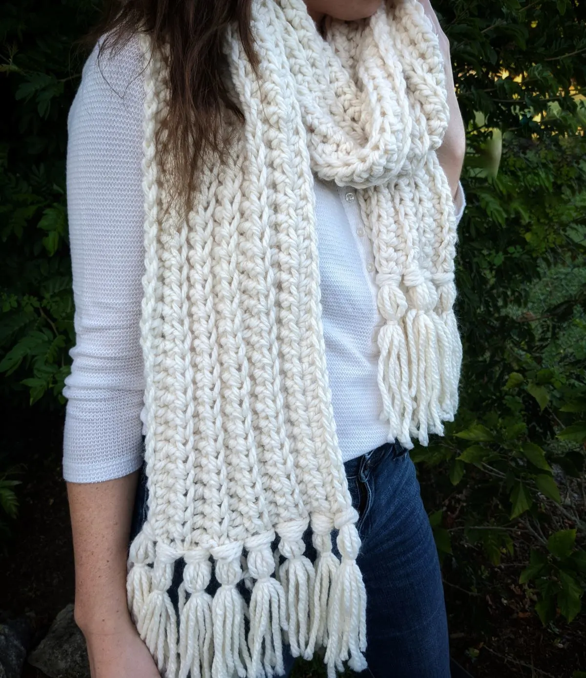 model is wearing a wrap around bulky weight crochet scarf for women