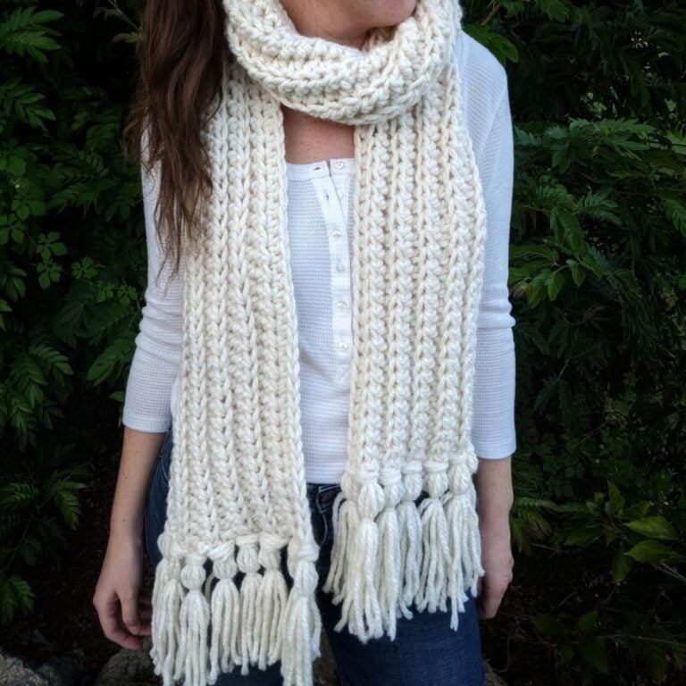 model is wearing a double thick chunky crochet scarf with tassels
