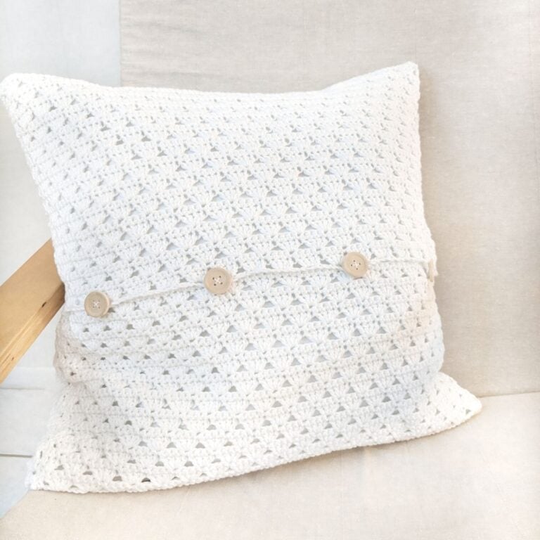 crochet pillow with buttons on a chair.