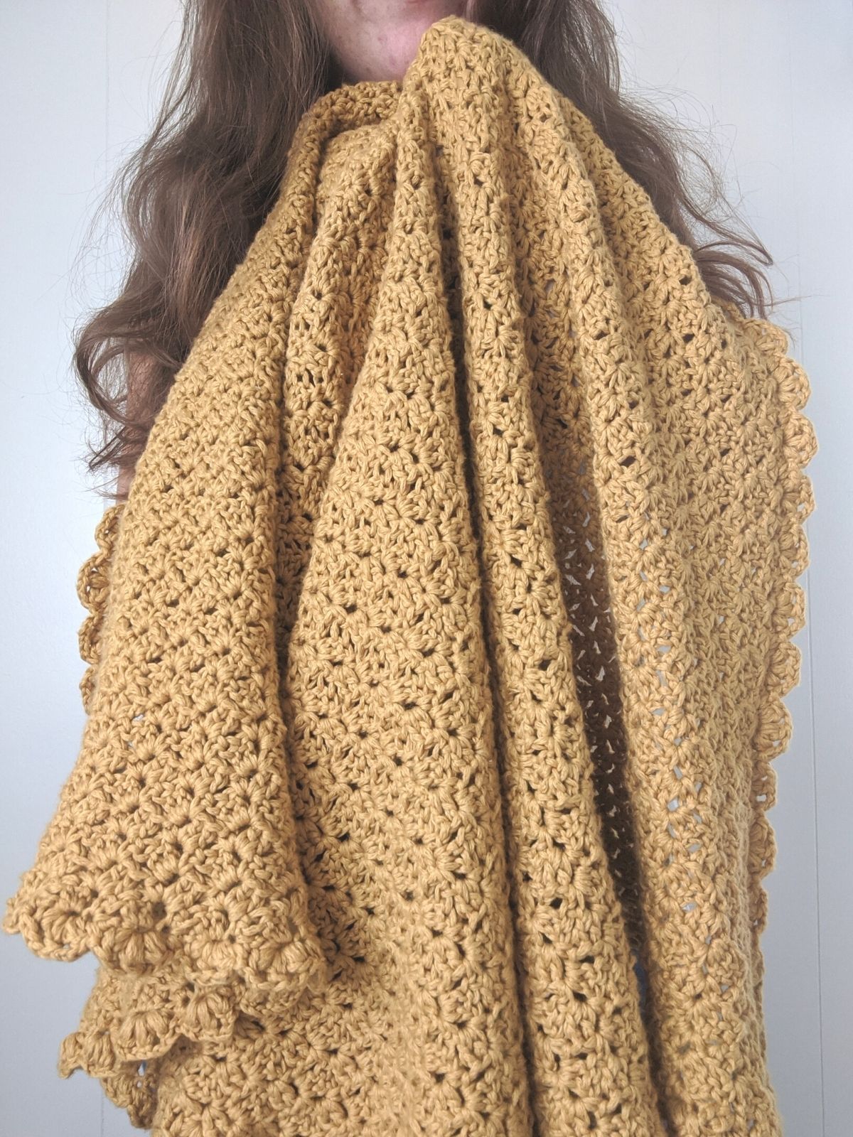 model is holding a yellow cotton crochet blanket