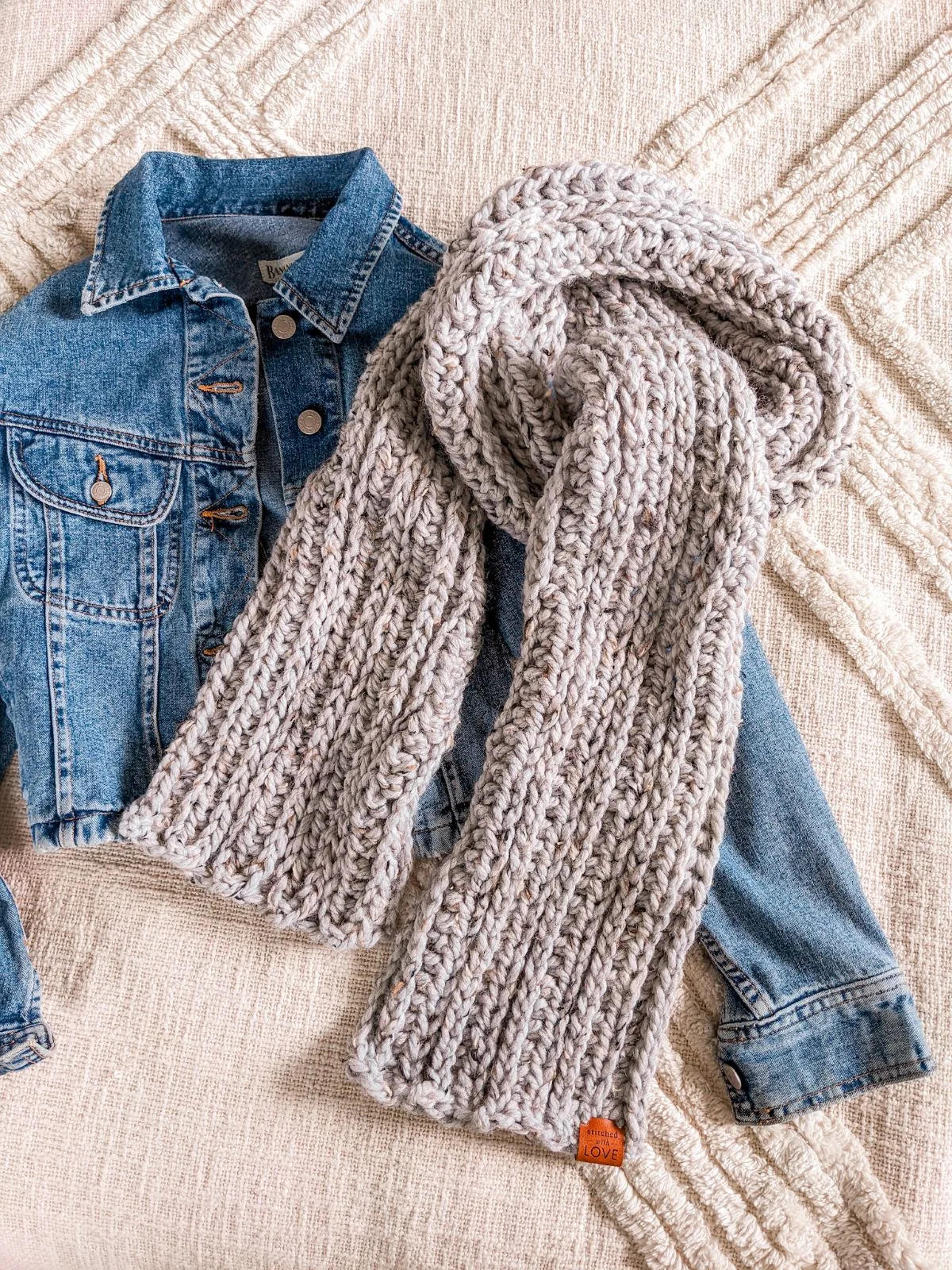 A crochet scarf with a jeans jacket.