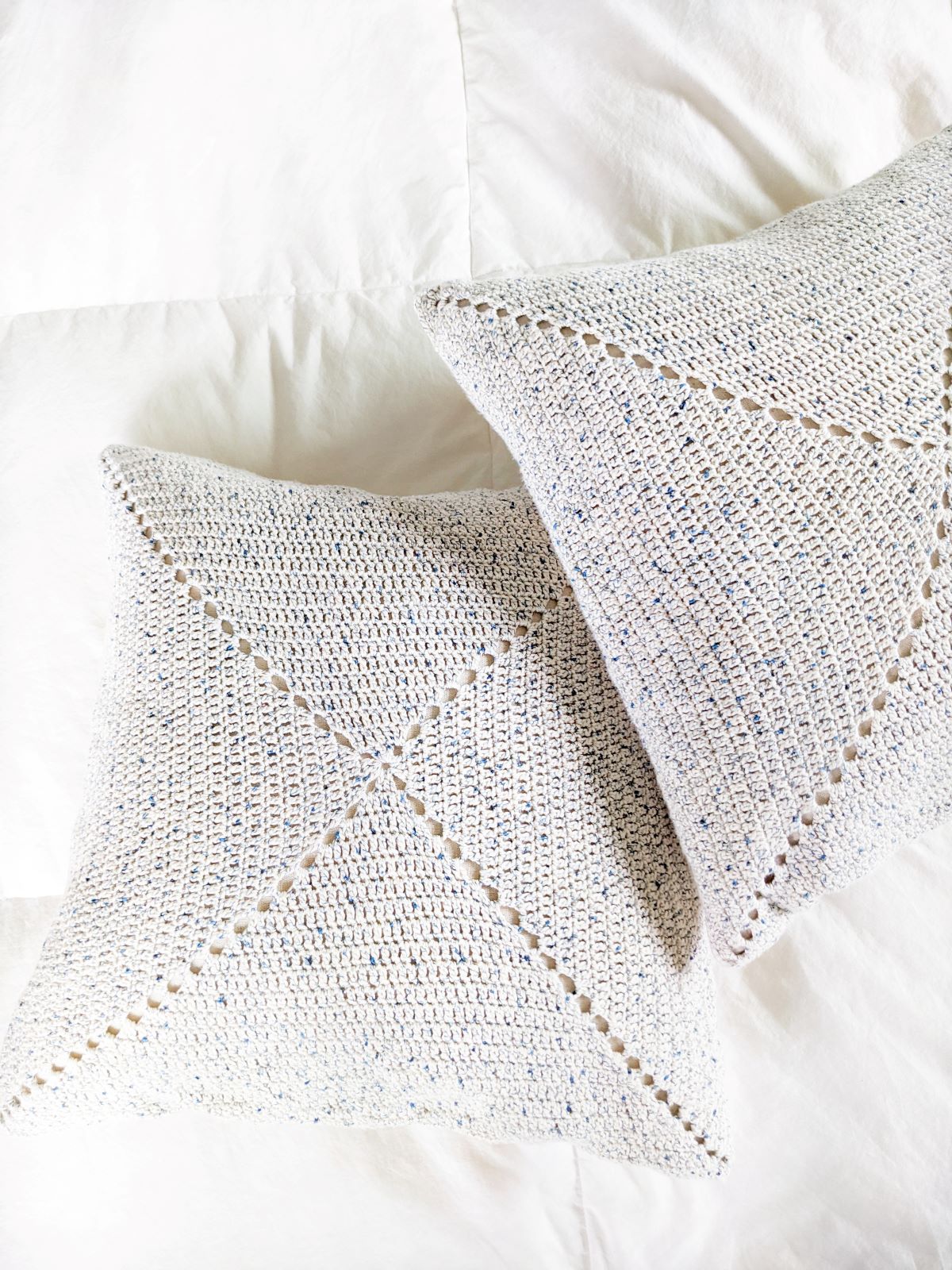2 double crochet granny square pillows on a bed