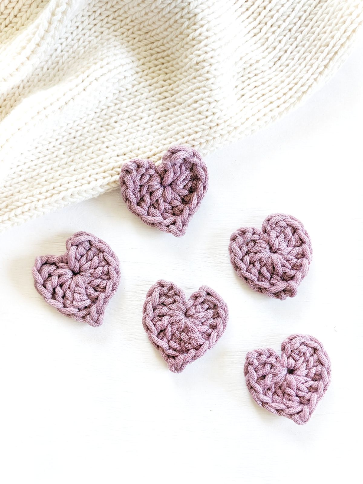 5 mini crochet hearts in the color purple.