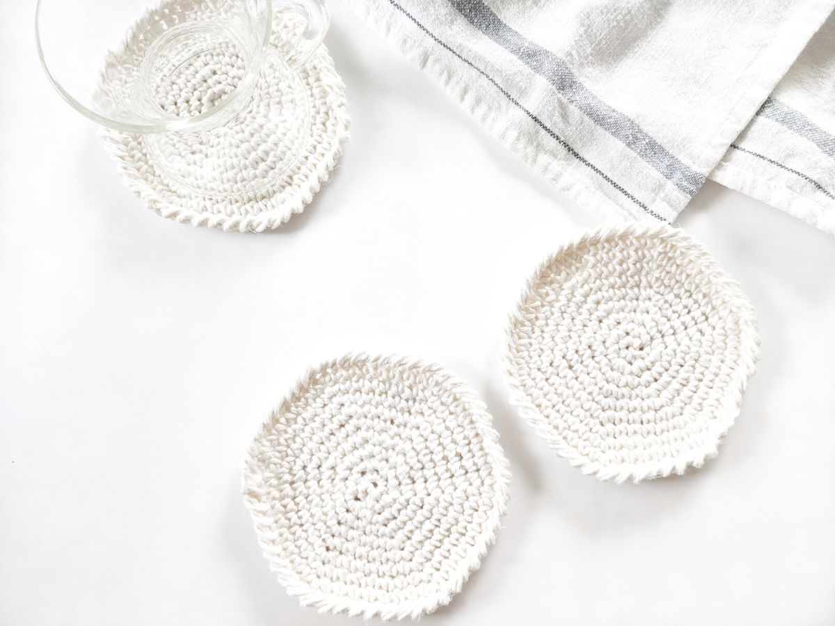 3 crochet circle coasters with a striped blue dishcloth