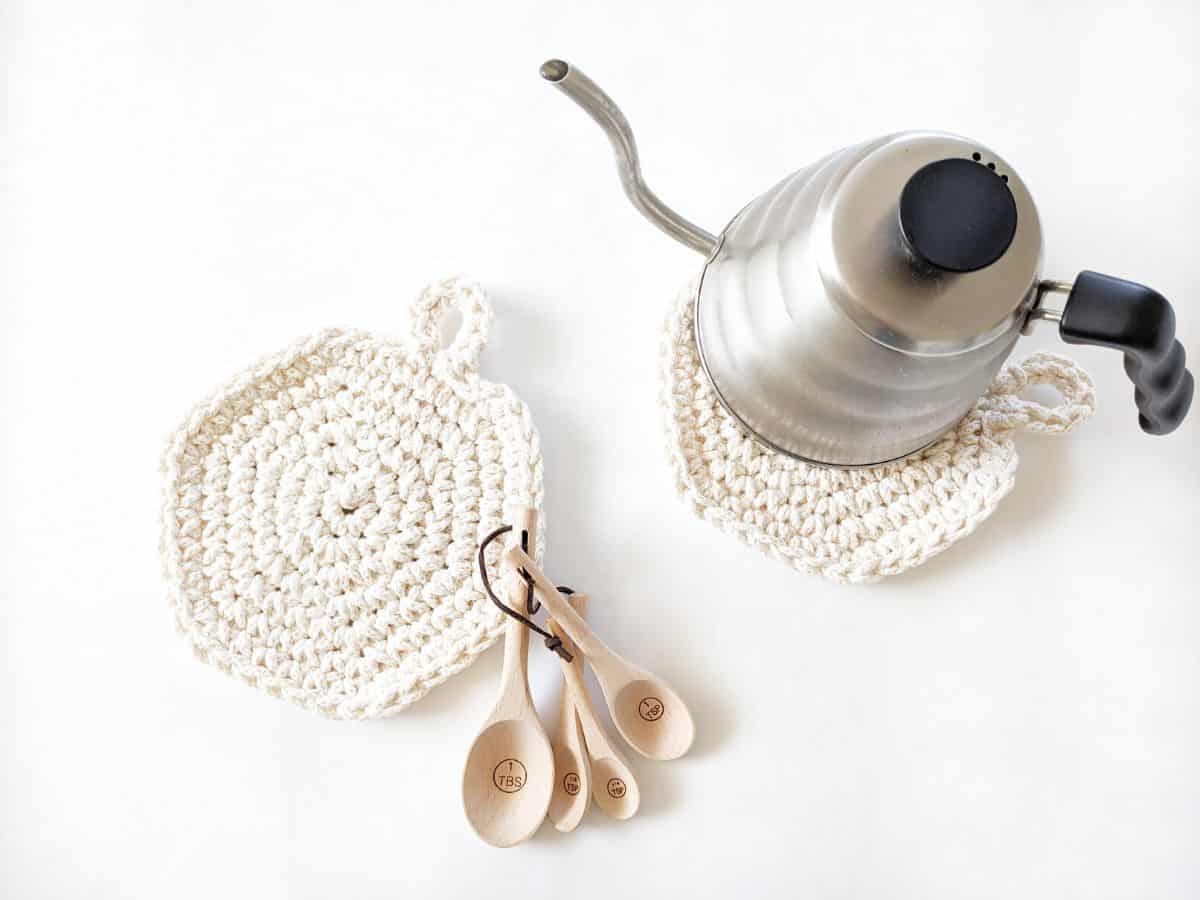 crochet hot pads in the kitchen with a tea kettle and wooden measuring spoons