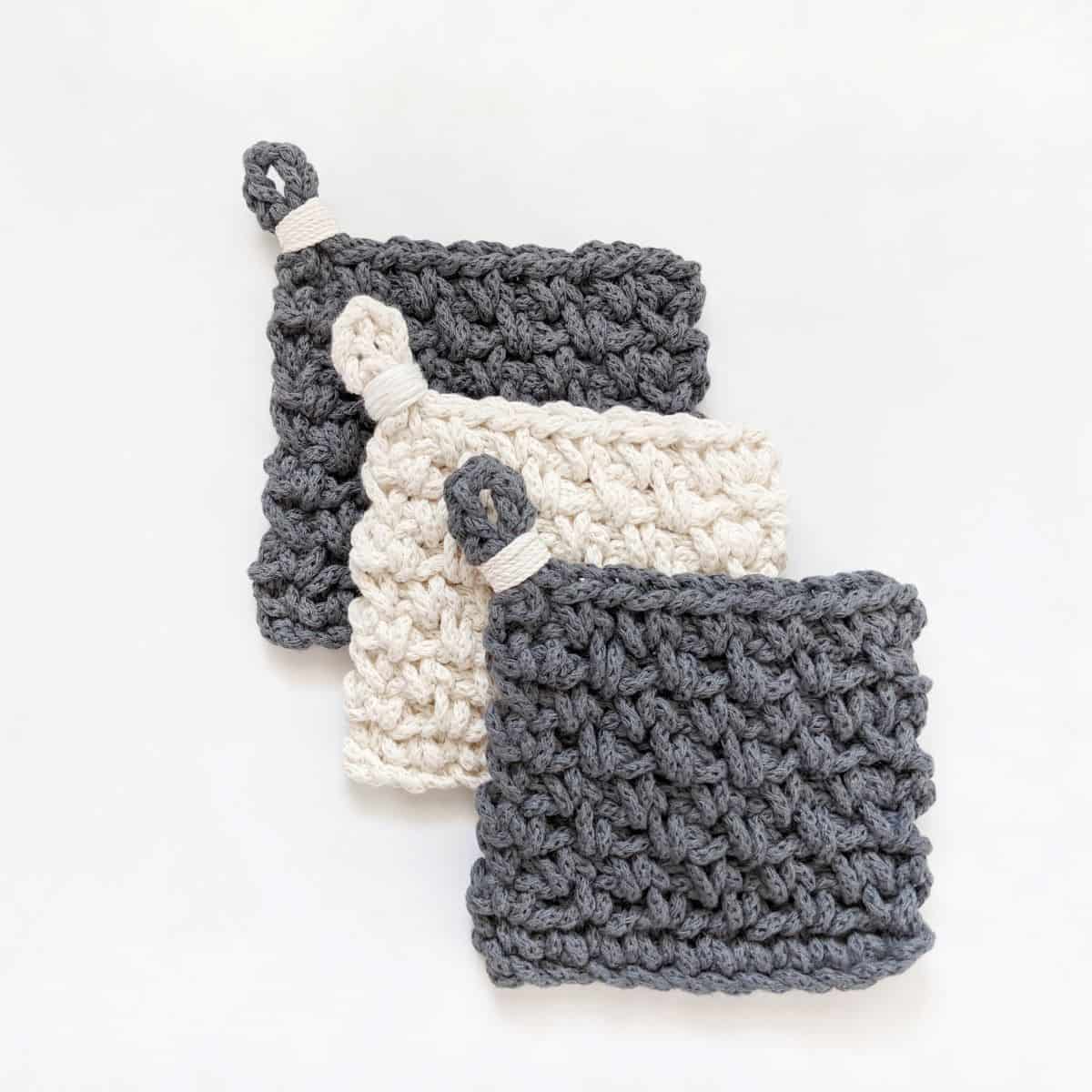 3 modern chunky crochet coasters made with cotton yarn in the color white and blue