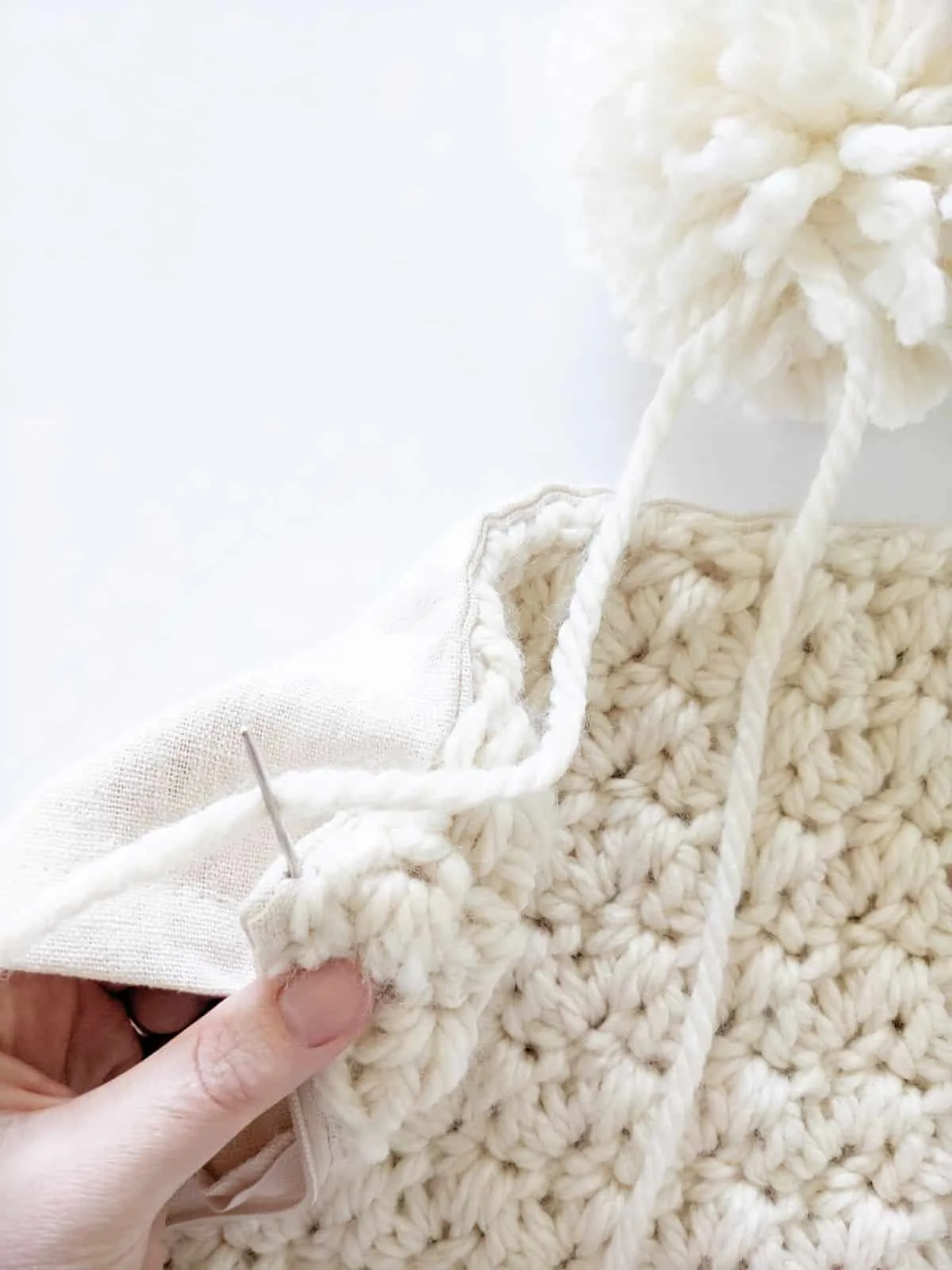 how to attach your pom pom to your crochet pillow cover