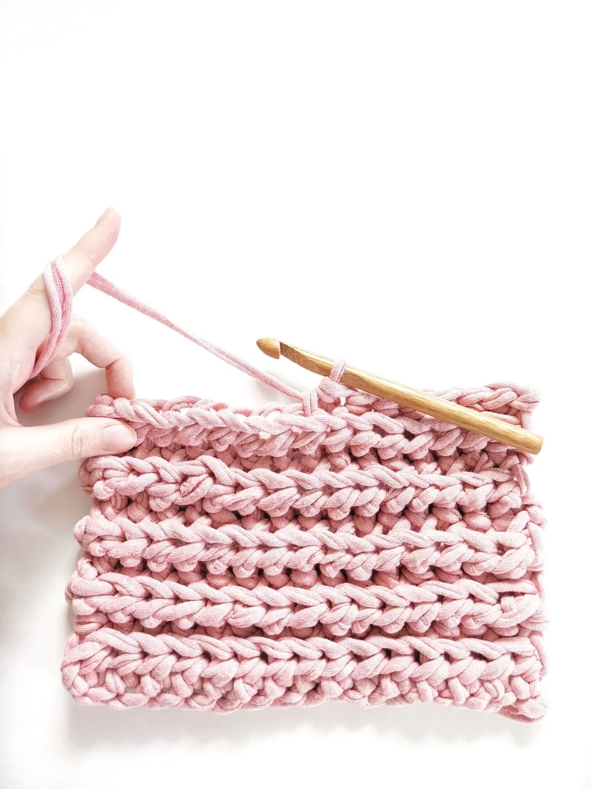 a swatch of the crochet knit-stitch with a wooden crochet hook.