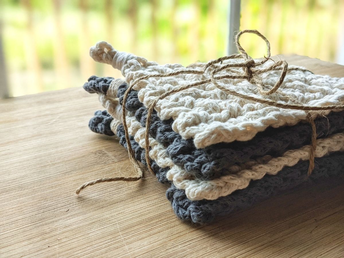 4 chunky cotton crochet coasters with twine wrapped around them for a housewarming gift idea