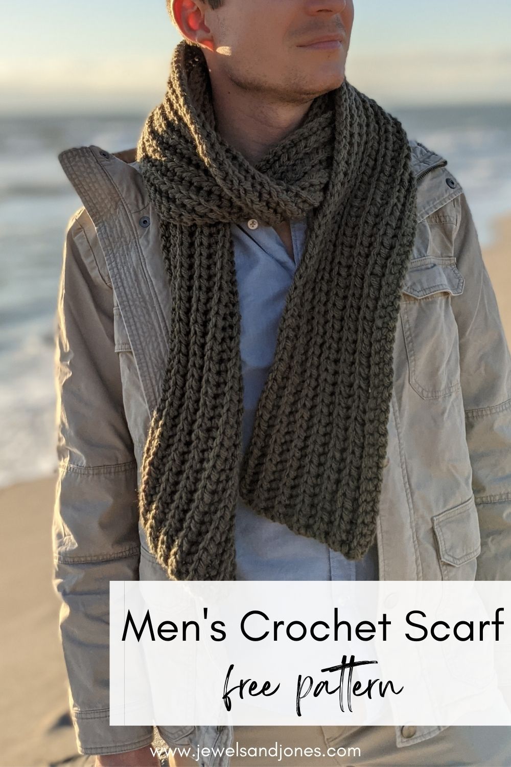 A guy is wearing a classic ribbed crochet scarf on the beach.