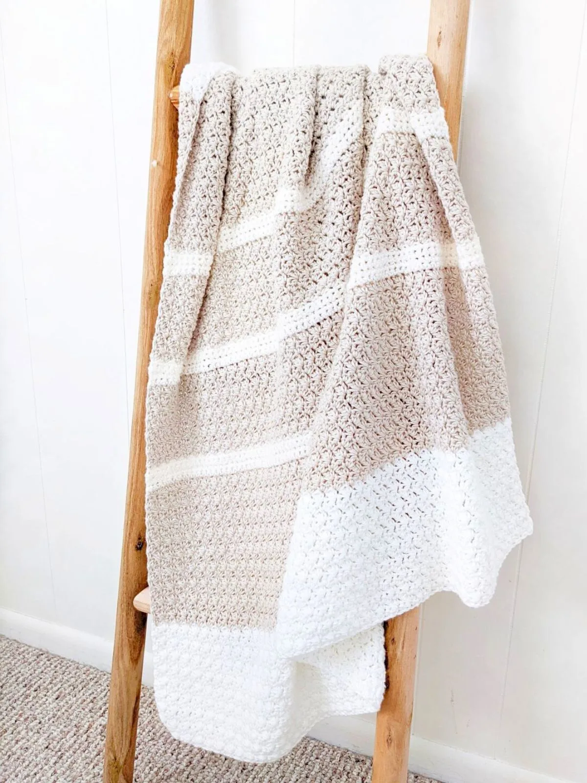 A crochet baby blanket that has stripes.