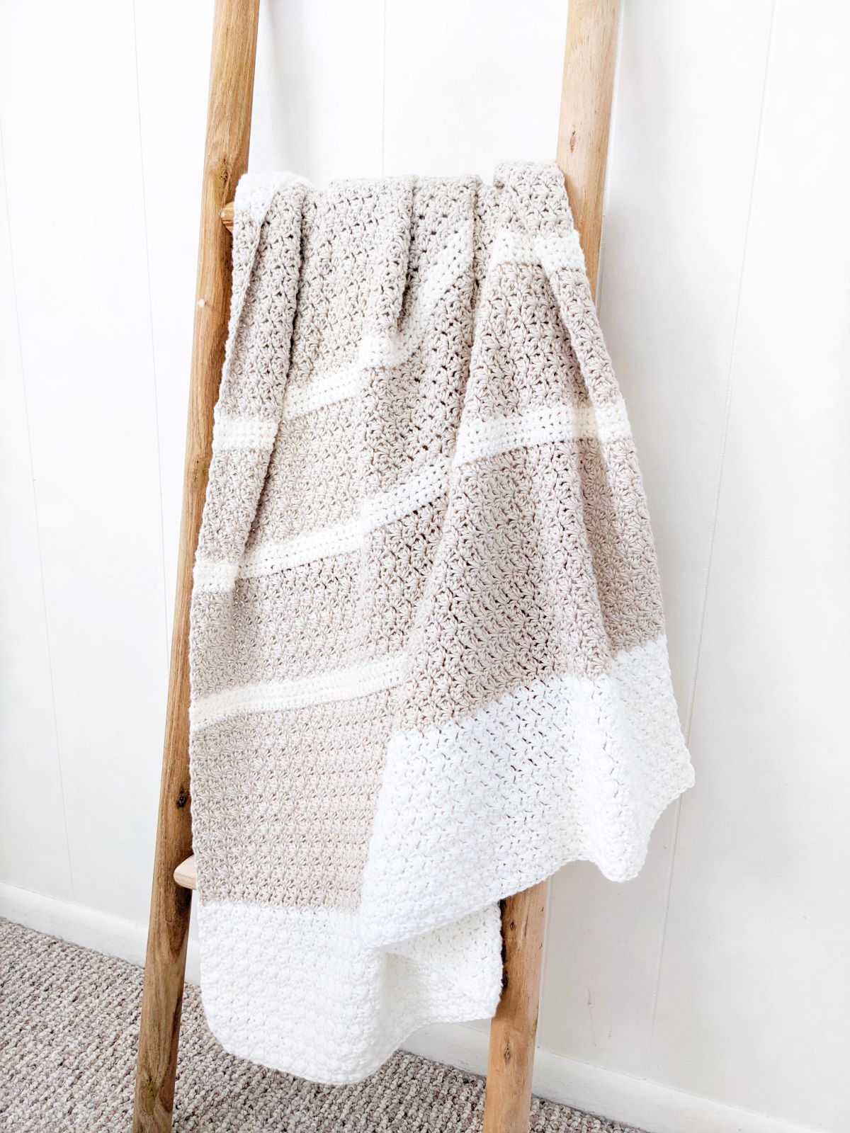 cozy cotton heirloom baby blanket on a wooden ladder.