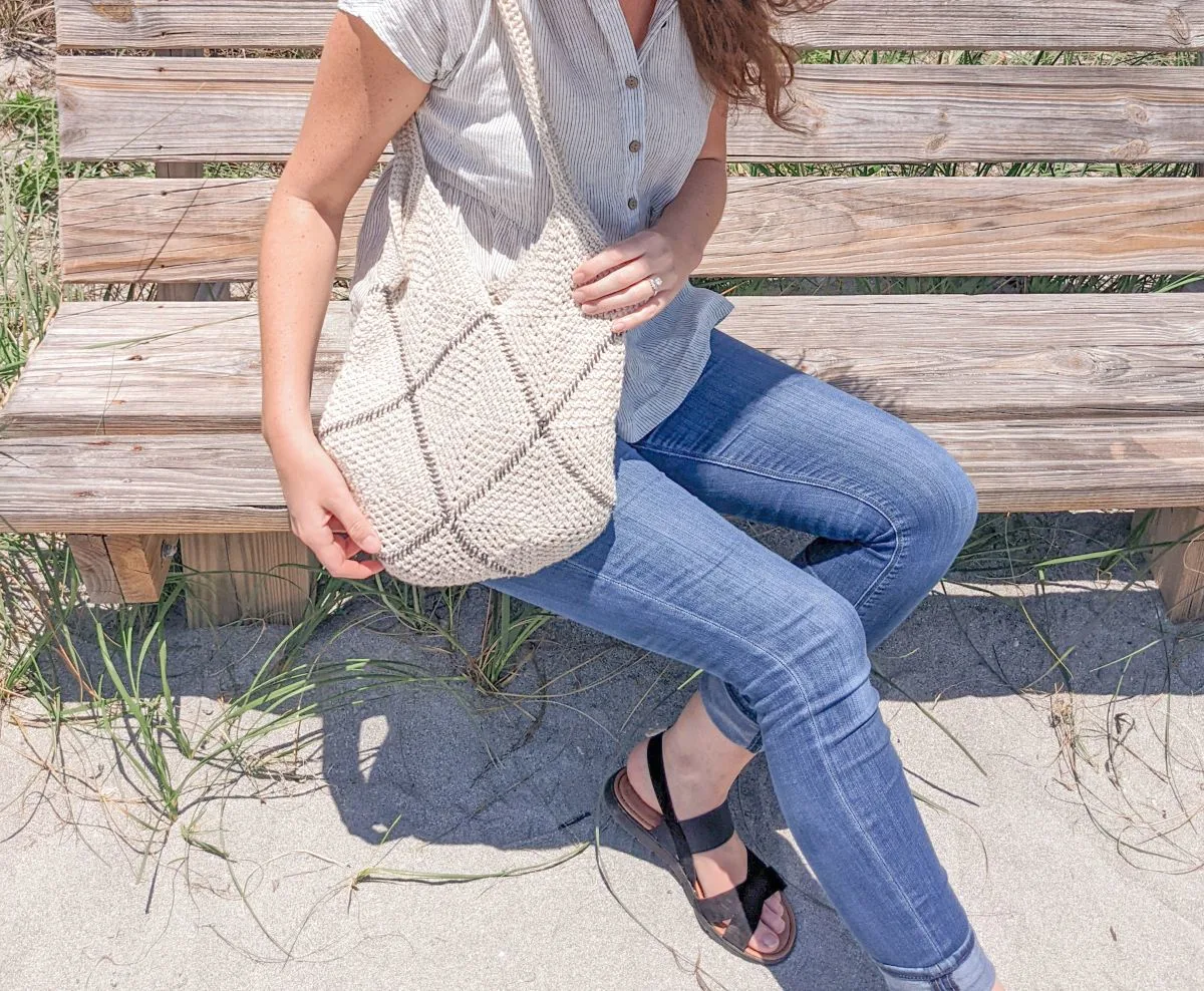 Model is holding a modern crochet tote bag.
