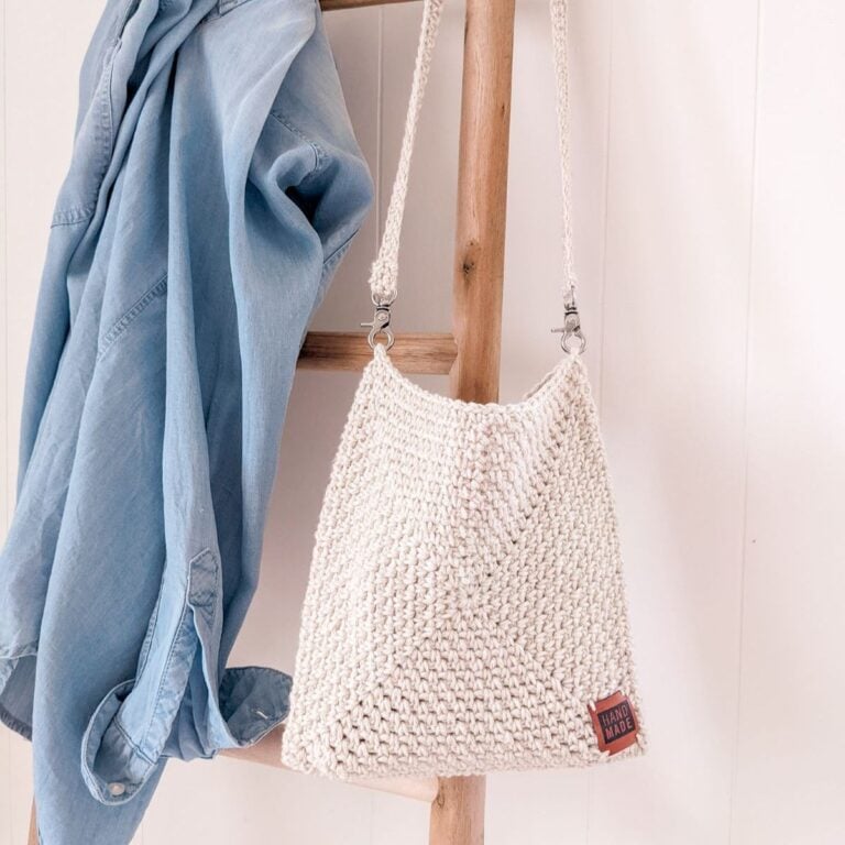 a crochet bag over a decorative ladder with a blue shirt.