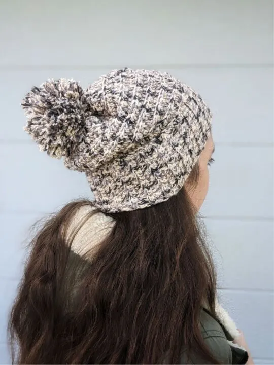 Model  is wearing a beanie that uses Lion Brand Comfy Cotton Blend Yarn.