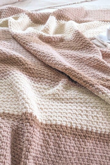 A free striped crochet blanket pattern that has 3 different colors.