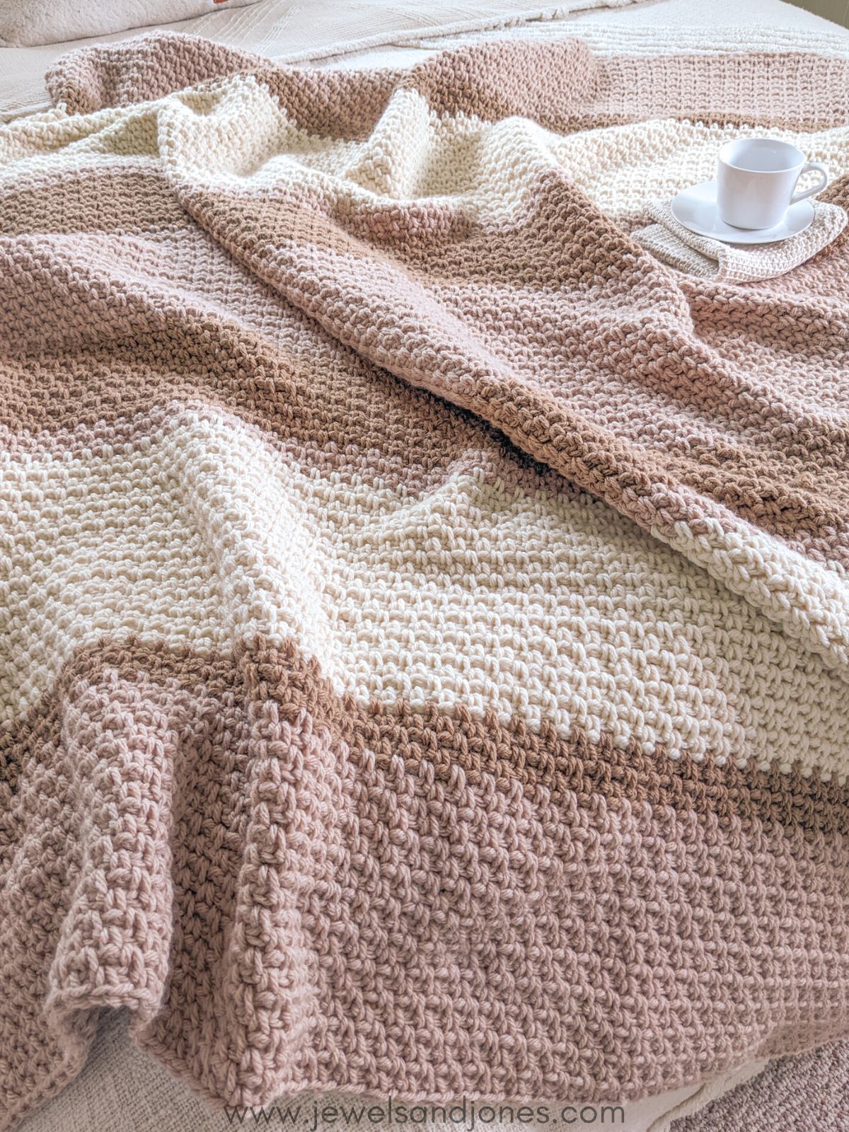 A mixed color crochet blanket that uses the moss stitch.