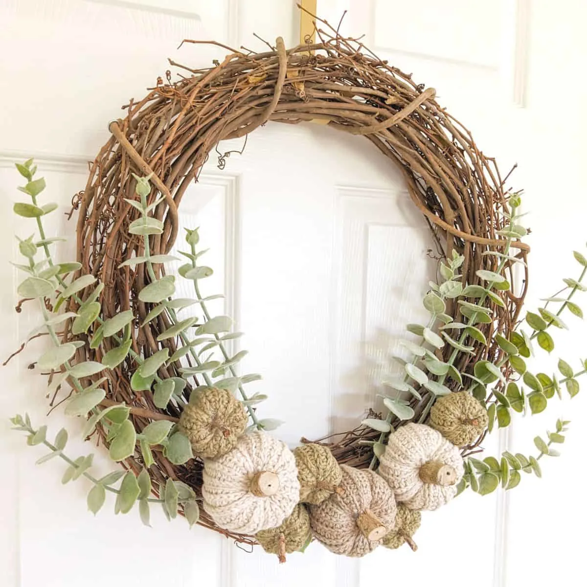 A large grapevine wreath with eucalyptus and handmade crochet pumpkins