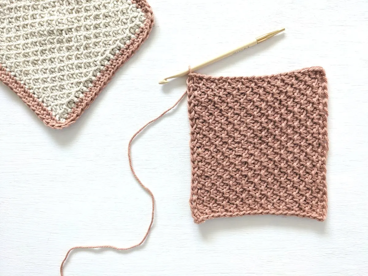 A pink cotton washcloth that uses the honeycomb stitch.