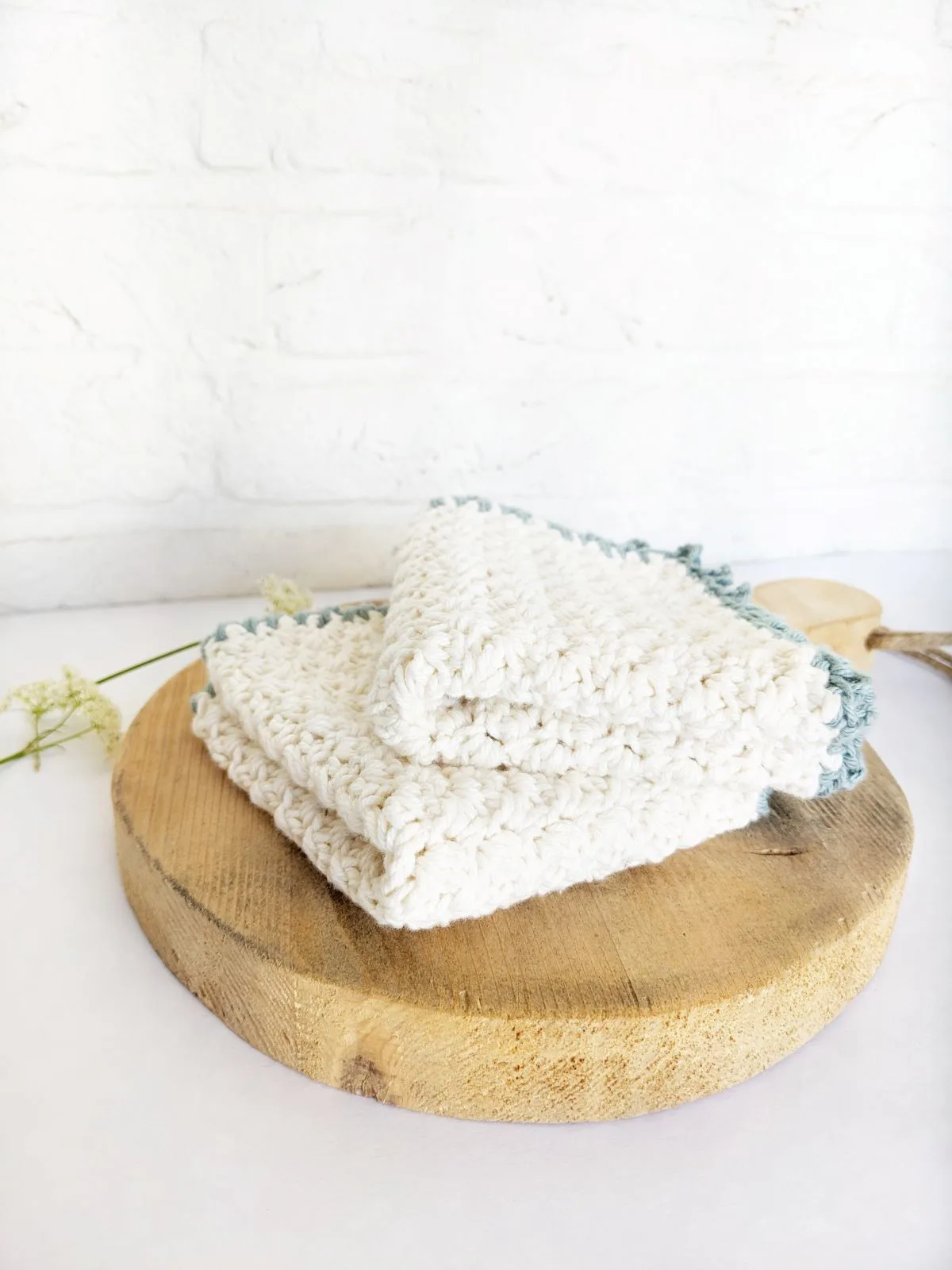 A cotton crochet washcloth on a wooden board.
