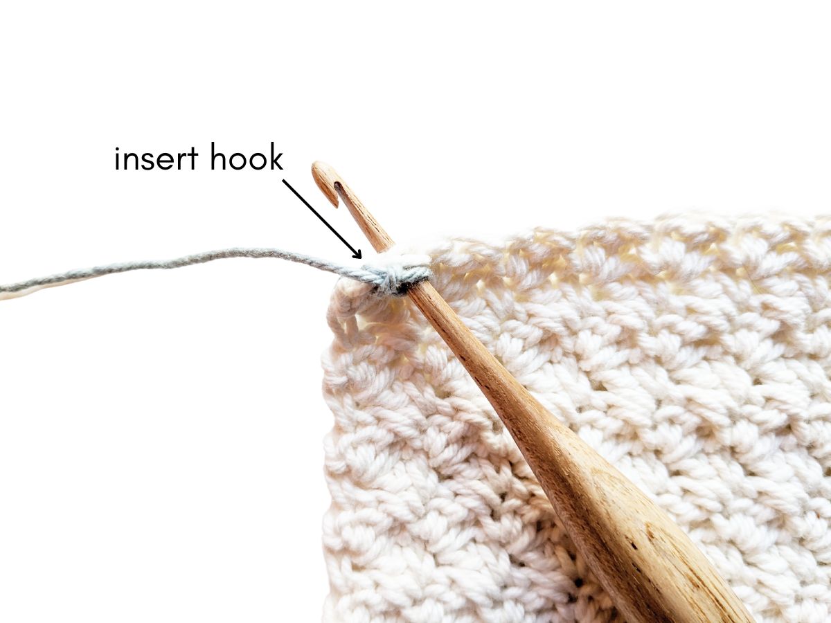 A crochet hook inserted into a stitch.