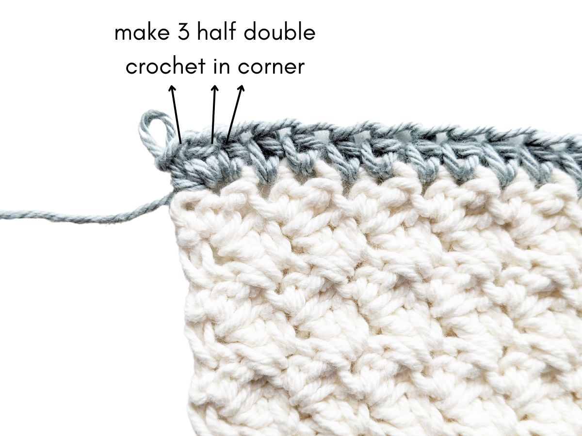 Adding 3 half double crochets to a corner to make a border.