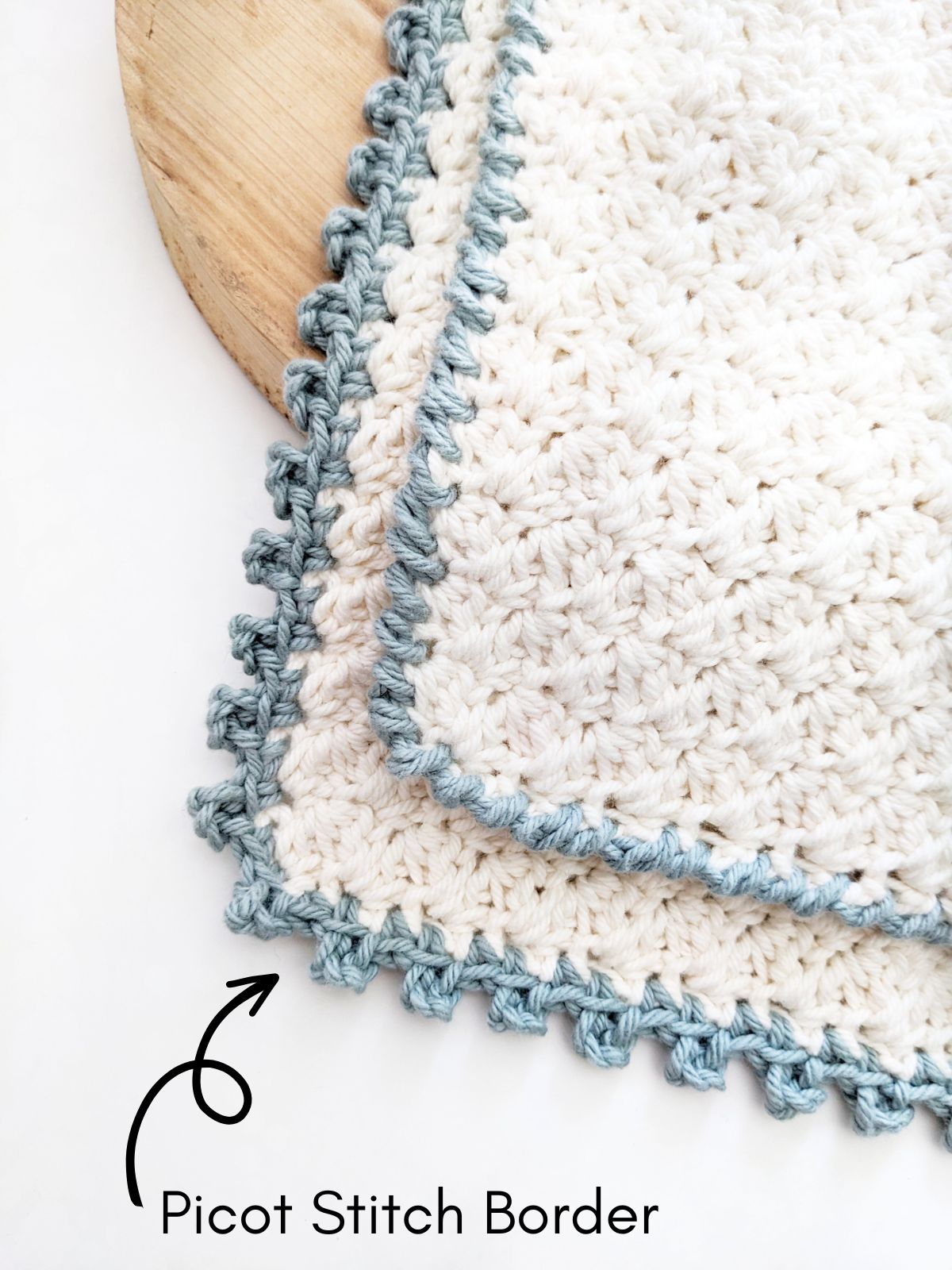 A cotton crochet washcloth with a picot stitch edging.