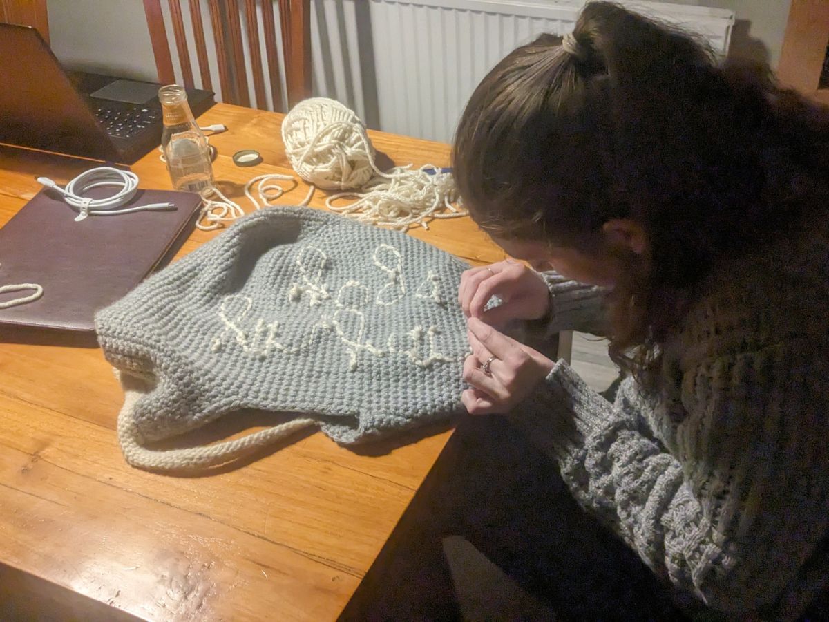 Crocheter working a crochet bag pattern.