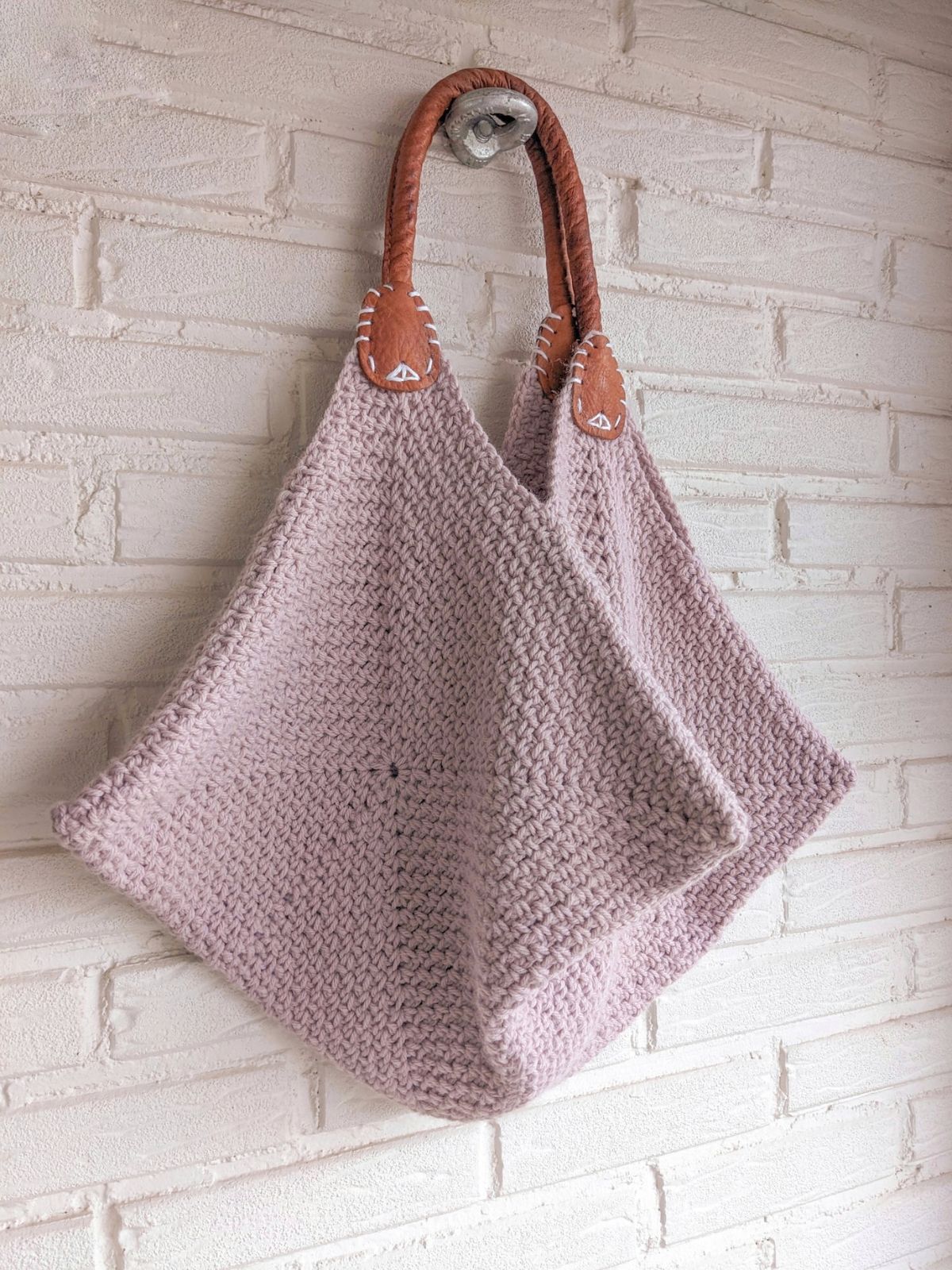 A crochet project bag made with 4 granny squares.