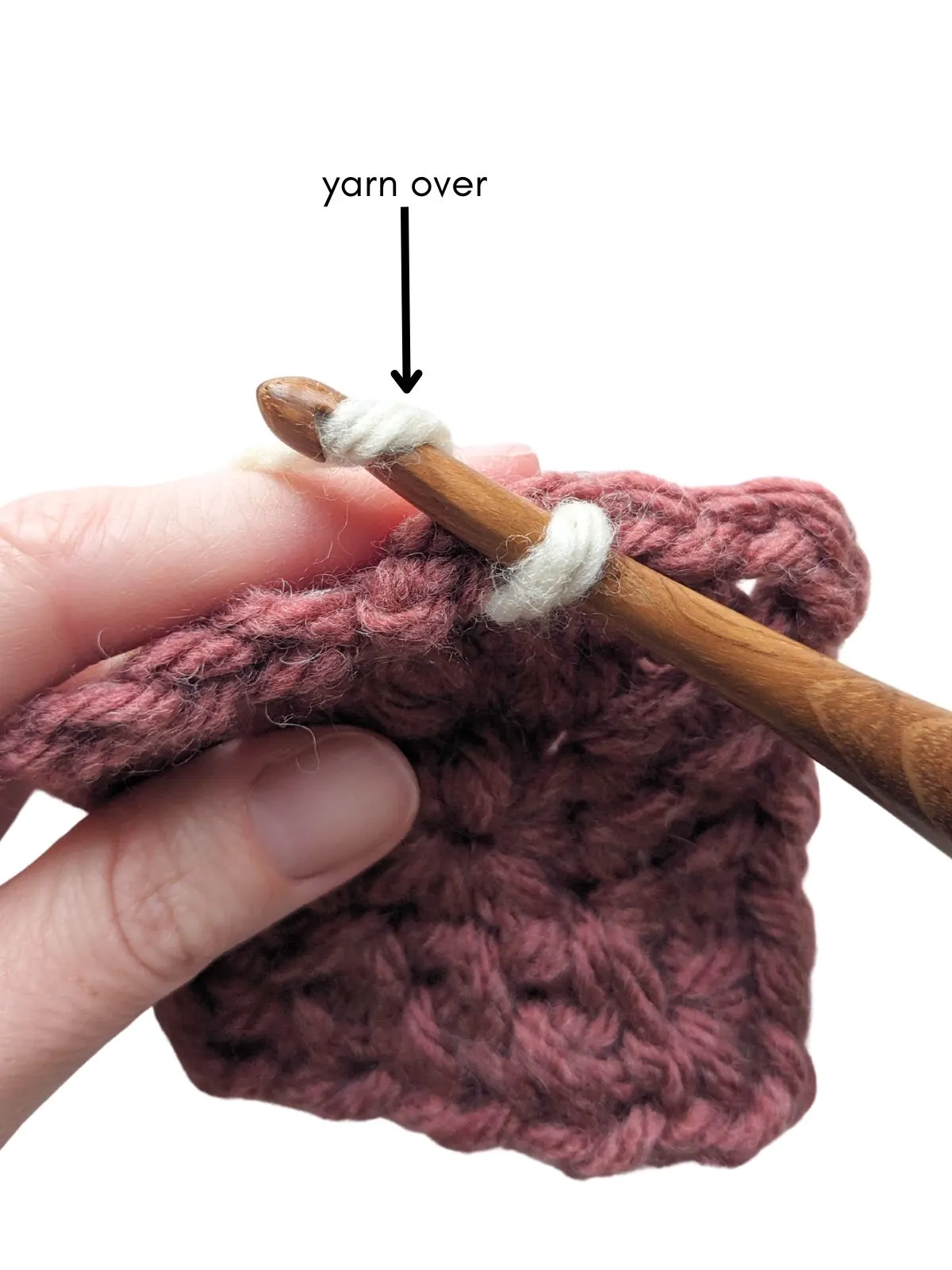 A stitch is being made with a crochet hook. 