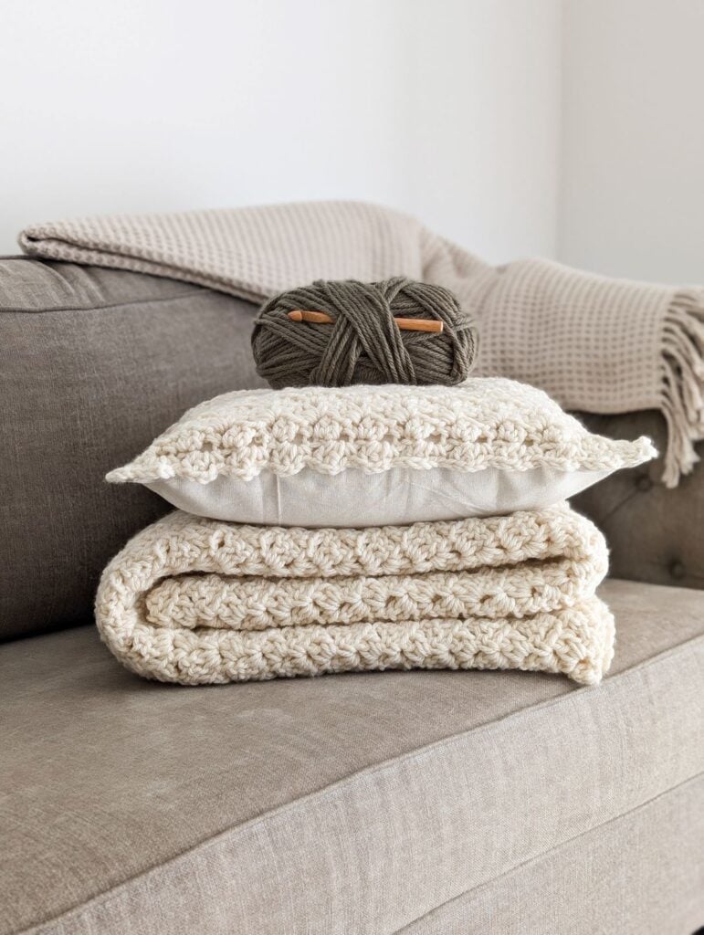 A crochet and blanket pattern set on the couch.
