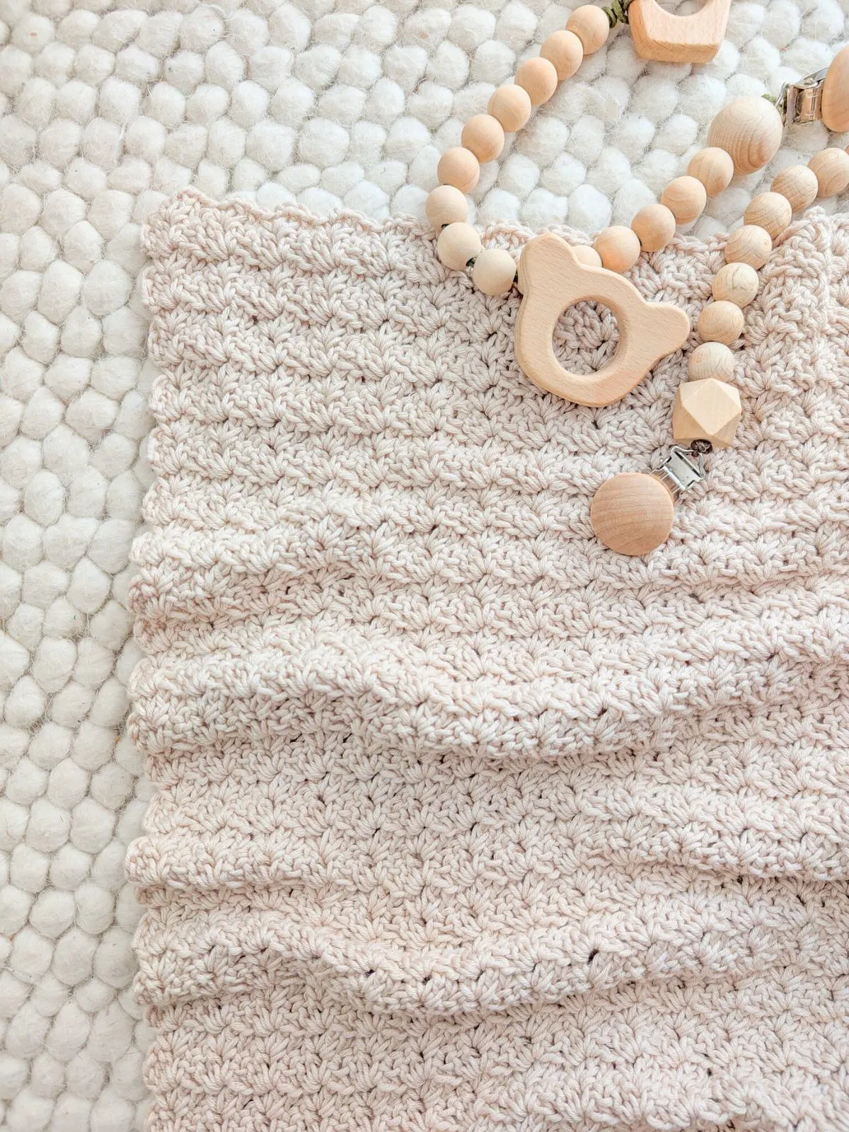 A simple crochet baby blanket with wooden toys.