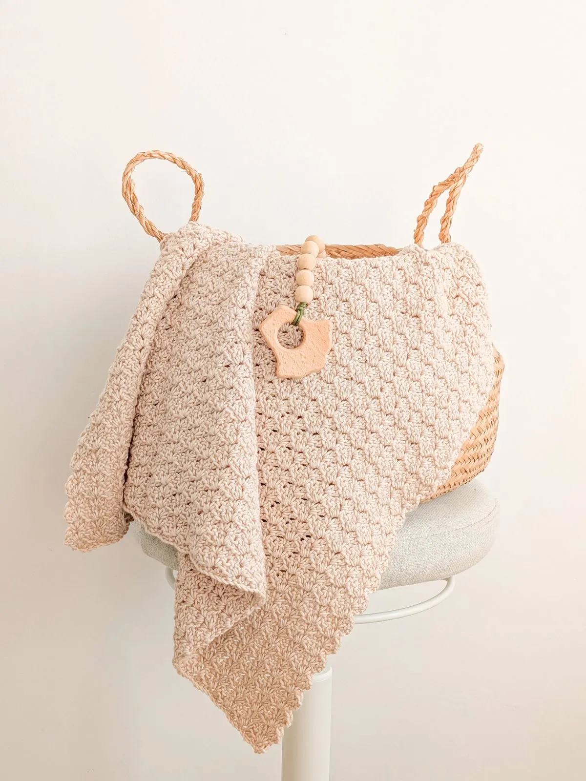 A crochet baby blanket in a belly basket.