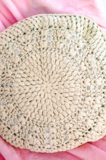 A round crochet pillow pattern with puff stitches.