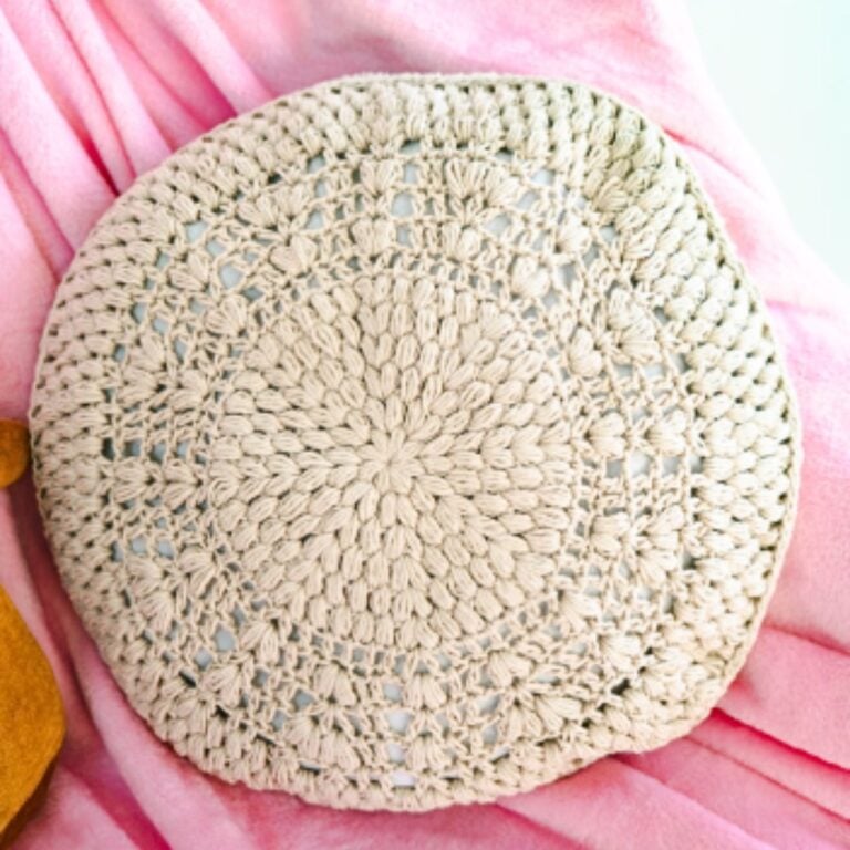 A round crochet pillow pattern with puff stitches.