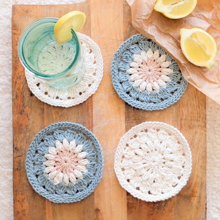 A crochet round coaster on a wooden block.