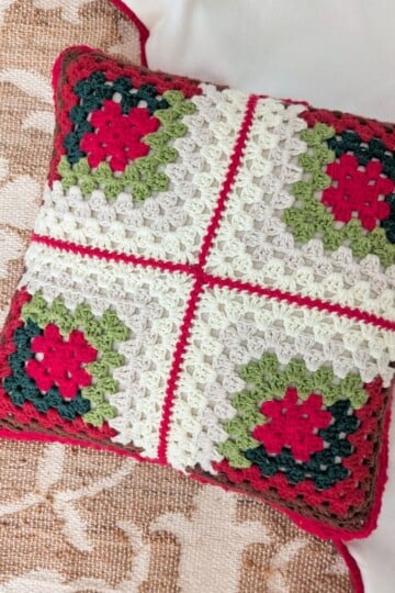 A Log Cabin Crochet Christmas pillow made from 4 granny squares.