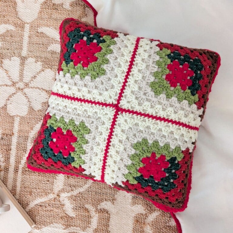 A Log Cabin Crochet Christmas pillow made from 4 granny squares.