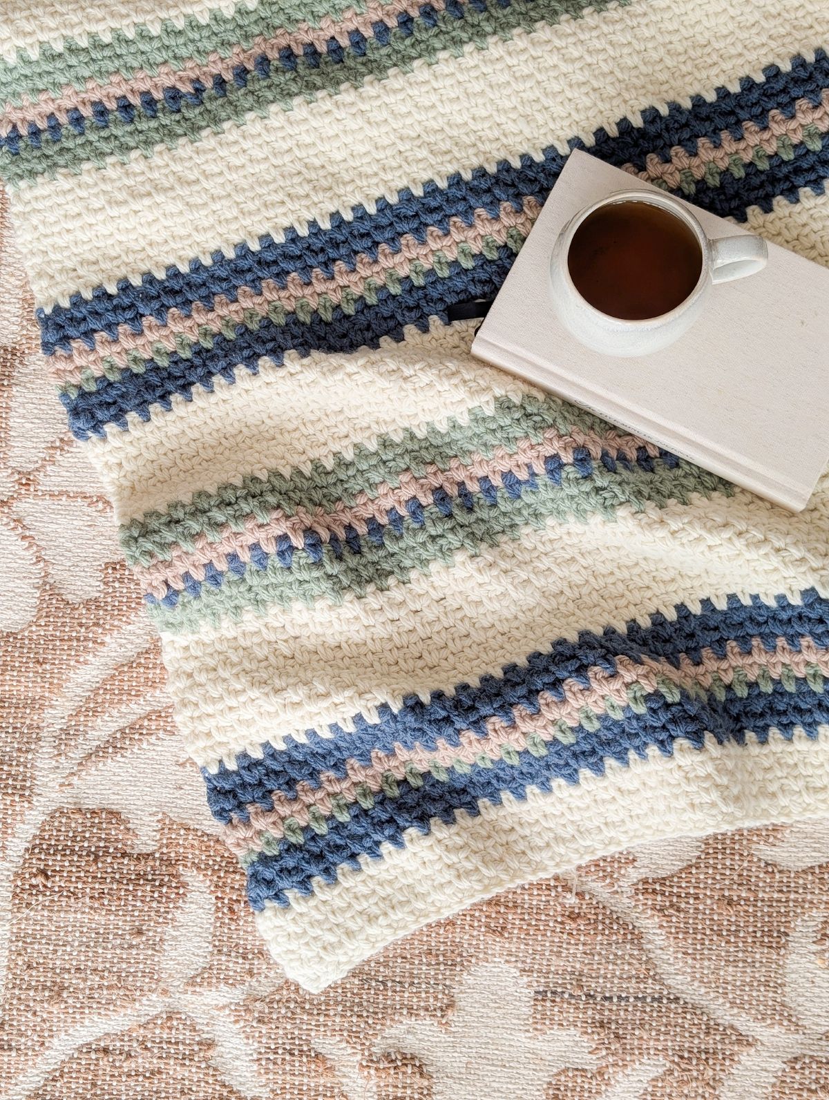 A 4 color striped crochet blanket pattern with a tea cup on it. 